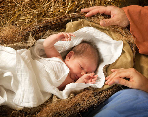 20 days old baby sleeping in a christmas nativity crib